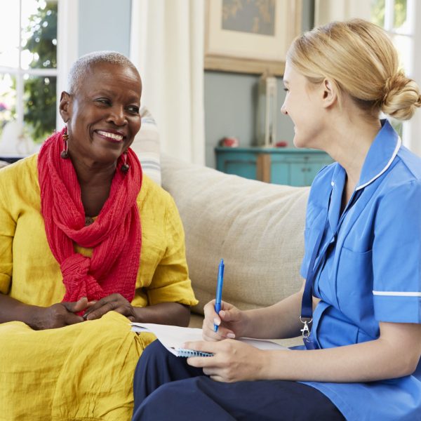 Female Community Nurse Visits Senior Woman At Home